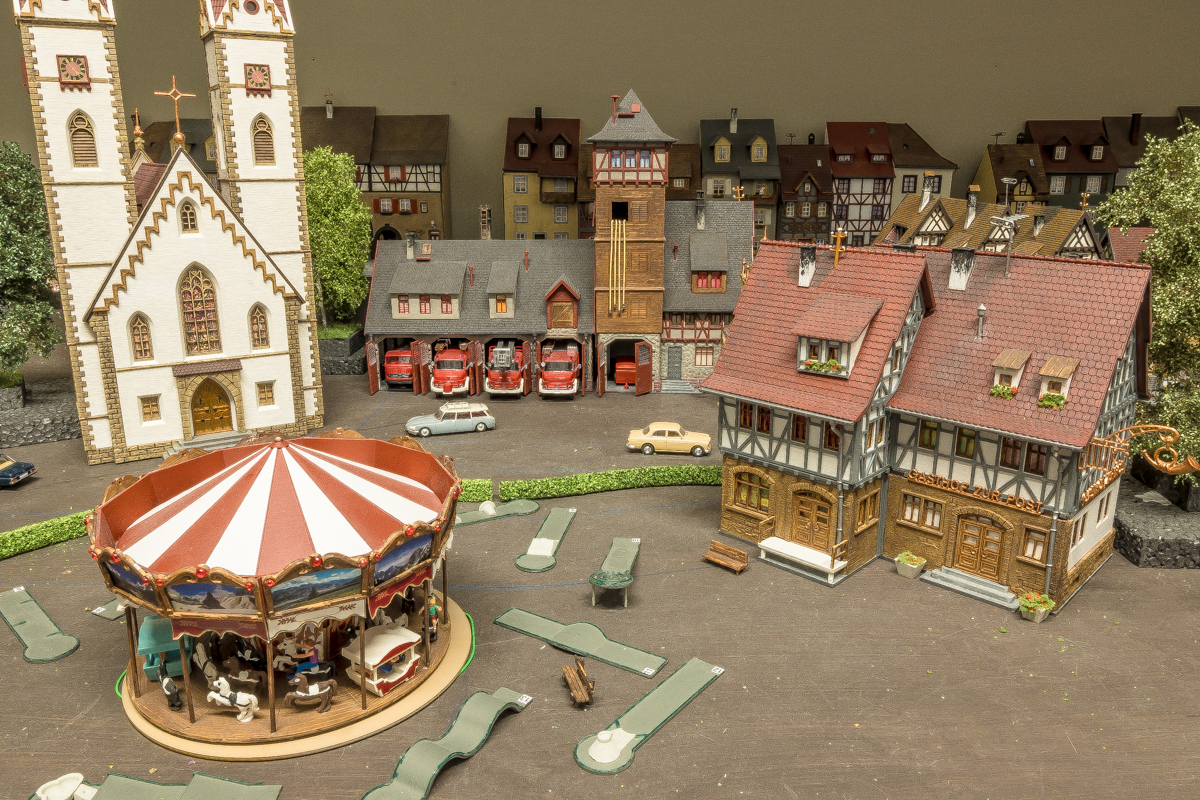 Op de voorgronde de carrousel die echt kan draaien en de midgetgolfbaan.